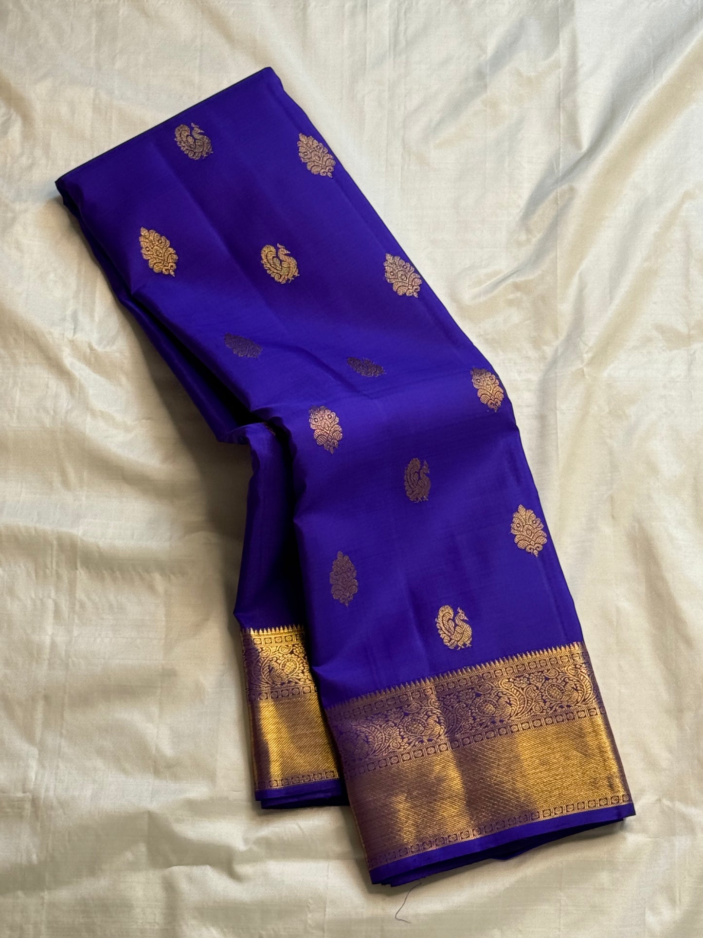 Blue saree with gold patterns on a beige fabric background